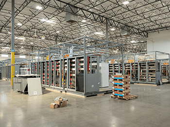 Modular industrial electrical control systems under assembly on a large manufacturing floor